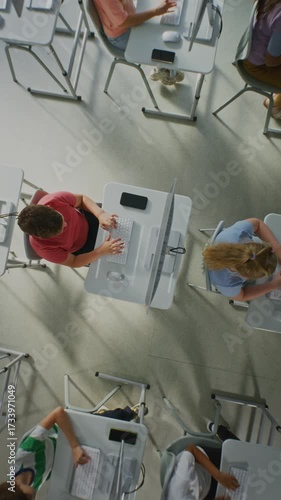 Modern Classroom With Children Learning Computers. Child Sits at Desk, Typing and Studying. Concept of Modern Digital Education, Computer Literacy, Teamwork Students. Rotating Top View. Vertical Shot.
