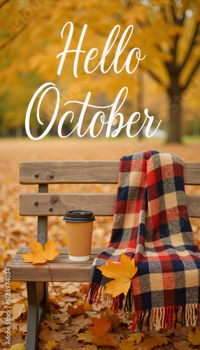 Wooden bench with plaid blanket and takeaway coffee cup surrounded by fallen maple leaves. “Hello October” text adds warmth and seasonal charm, evoking comfort, tranquility, and fall mood.