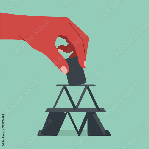 Hand carefully places a card atop a precarious tower of cards