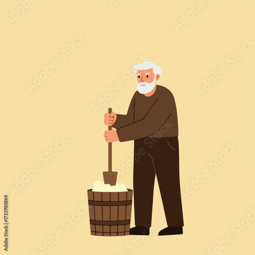 Elderly man churning butter in a wooden bucket