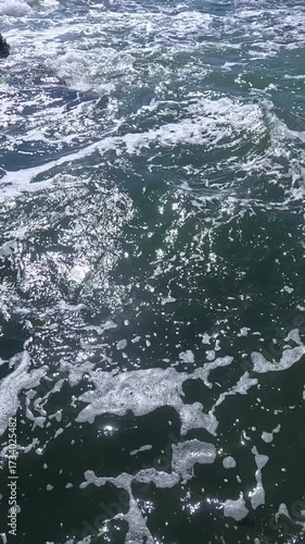 A storm at sea on a sunny day, white foam on the surface of the water