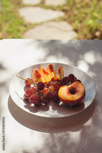 Peach and Grapes on White Plate with Floral Shadows, Sardinia, Horizontal Close Up with Copy Space