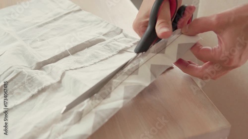 4K Ultra HD Close-up Shot Woman Hands Cutting textile Sheet With Metal Scissors Sharp Blade on Wooden seamstress's table Professional and small Business concept video.