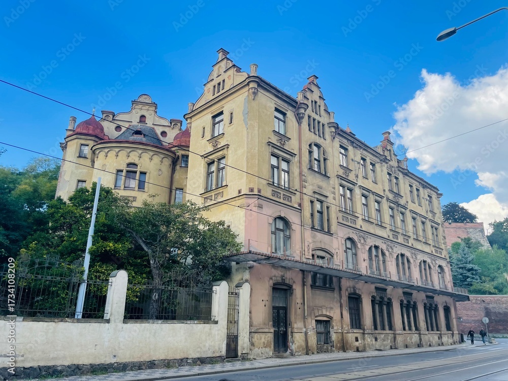 Fototapeta premium An ornate historic building, located in an urban area, presents a stunning view against an open, clear blue sky