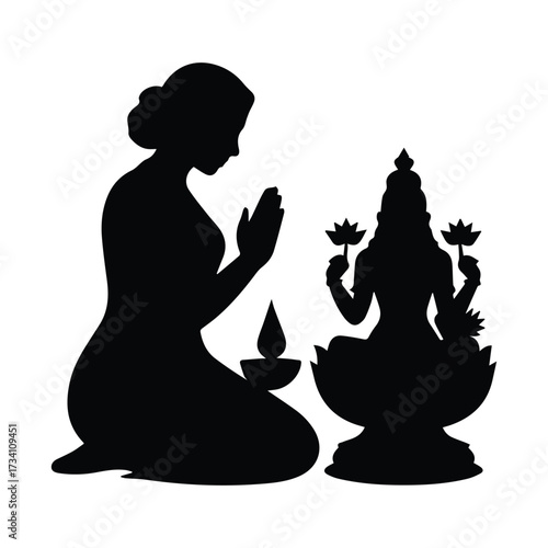 Silhouette of woman praying before goddess lakshmi with oil lamp during religious ritual silhouette
