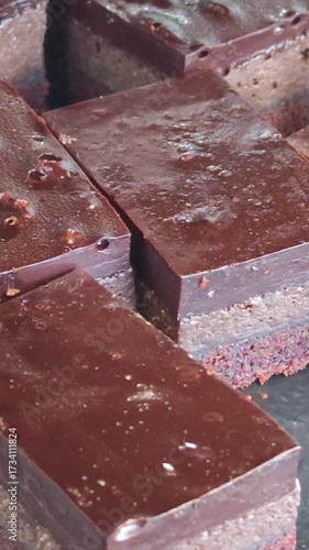 Freshly baked slices of chocolate brownies on display on a market stall.