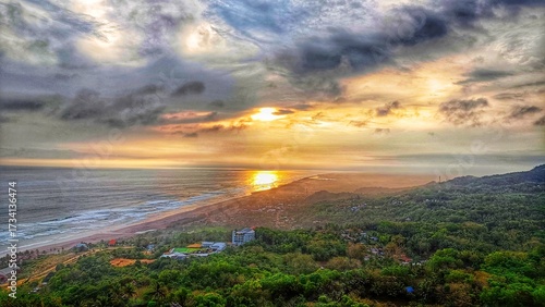 aerial landscape of sunset between the beach and green forest