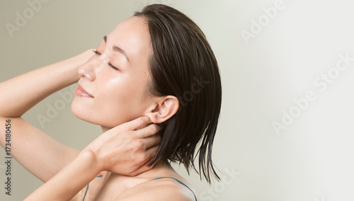 ヘアケアをしている女性/艶肌で髪が濡れている/40代日本人女性のビューティーポートレート。