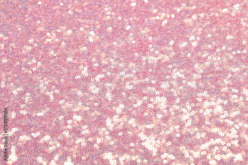 Close-up of shimmering pink spangle fabric with sequins creating a sparkling texture, perfect for fashion, textiles, and luxury design backgrounds.