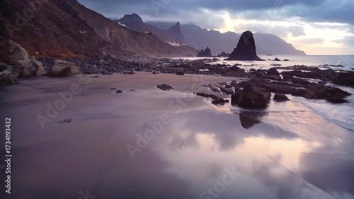 Aerial drone footage of Benijo Beach in Tenerife, Canary Islands. The video shows volcanic black sand, dramatic cliffs, rock formations in the Atlantic Ocean, and powerful waves crashing on the shore