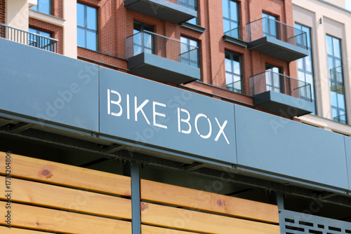 Modern bike storage box garage for residents near apartment building, urban cycling infrastructure and sustainable city development concept
