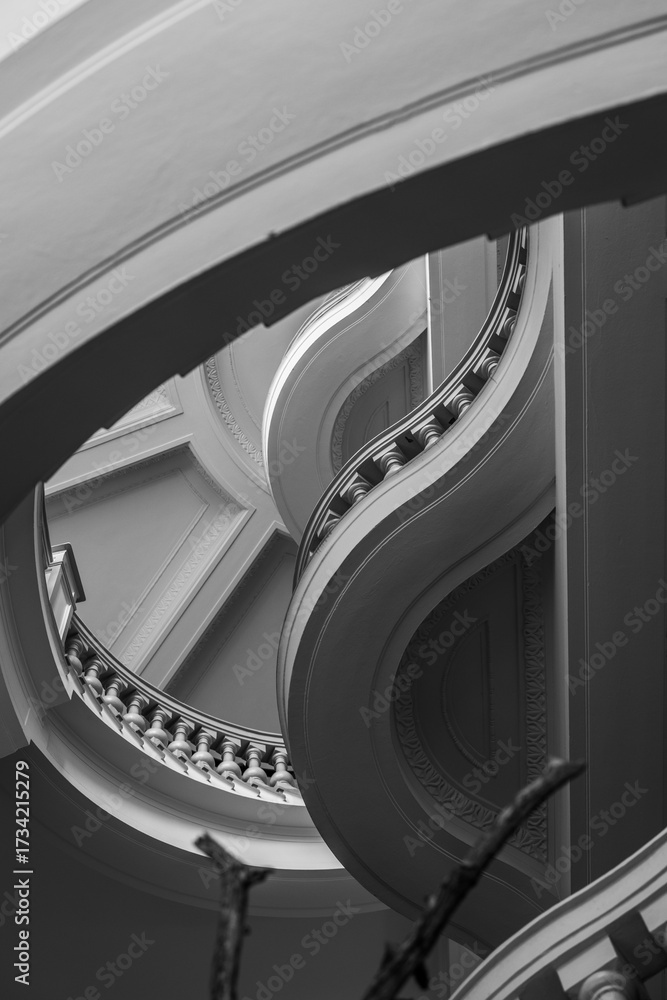 Fototapeta premium Curved staircase interior with ornate railings.