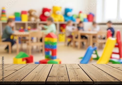Wallpaper Mural Blurred image of children playing in a kindergarten classroom with toys and furniture, with a wooden table in the foreground Torontodigital.ca