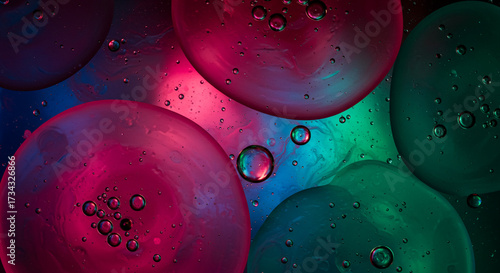 Vibrant abstract background of colorful pink and blue oil bubbles in water creating a cosmic pattern