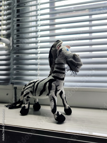 a toy zebra by the window