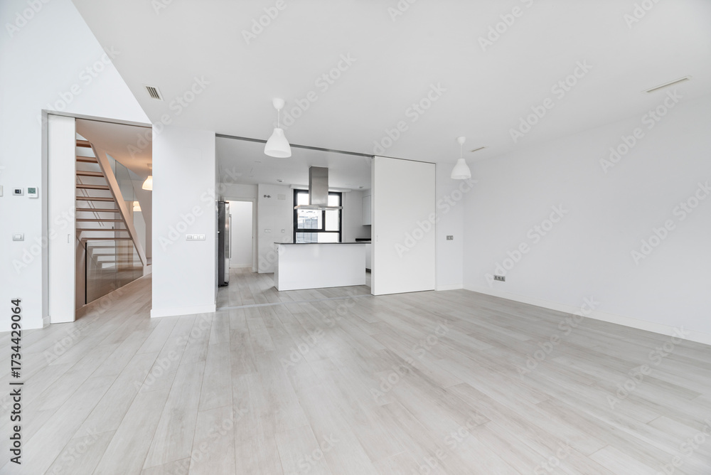 Obraz premium Open-plan basement space with a central access staircase and exposed structural pillars, perfect for dividing into rooms.