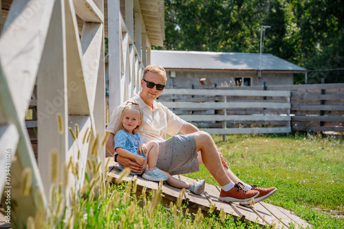 Foto A father sits with his daughter girl child in a beautiful garden on the steps of