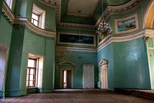  hall in a huge abandoned palace. The interiors of an abandoned 18th-century palace. Beautiful architecture. Light from the windows falls into the em