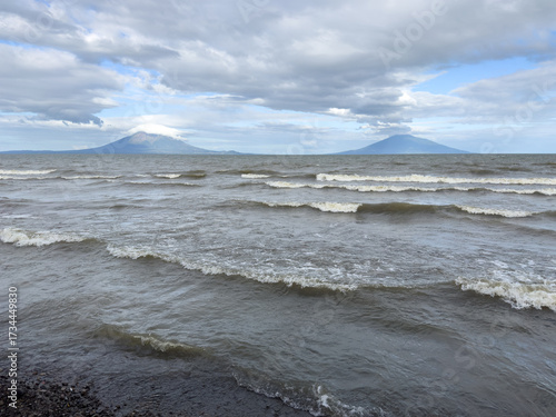Majestic twin volcanoes rise above choppy waters under cloudy sky in Nicaragua