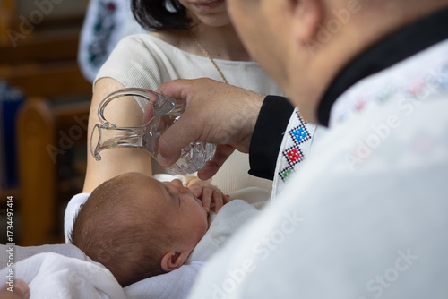 Photos Priest pouring holy water on baby’s head during christening ceremony in Greek Catholic church