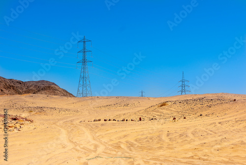 Power line transmission towers surround the Sahara in the desert in Egypt