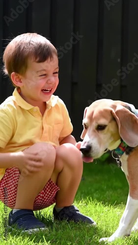 Child and Dog Crouching on Grass. Beagle Sniffing Child's Face Playfully. Heartwarming Pet Interaction.