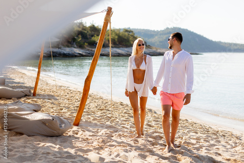 Couple walks hand in hand o...