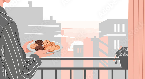 Person holding a plate of assorted cookies on a balcony with city view at sunrise