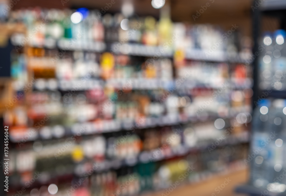 Fototapeta premium vibrant, abstract background shot of a liquor store or supermarket aisle, featuring rows of colorful, out-of-focus bottles. ideal for retail and beverage use