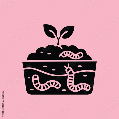 Young sprout growing in soil with worms and organic matter, representing soil health and sustainable gardening practices