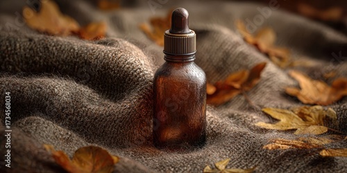 Amber Dropper Bottle on Soft Brown Wool Surface with Dried Leaves