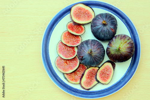 Fresh figs, sliced and whole, on a blue and white plate.