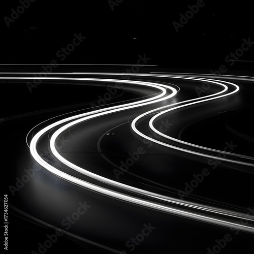Abstract light trails of a winding road at night, creating a dynamic and futuristic motion blur effect against a dark background