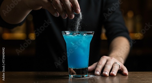 Close-up of bartender hand secretly adding substance to drink, concept of drink tampering and danger