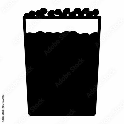 Black silhouette of a glass full of a liquid with coffee beans