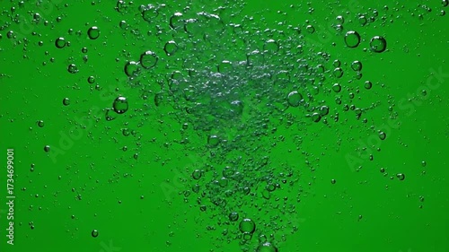 Bubbles rising in vibrant green liquid creating dynamic underwater motion perfect for refreshing beverage commercials or nature scenes