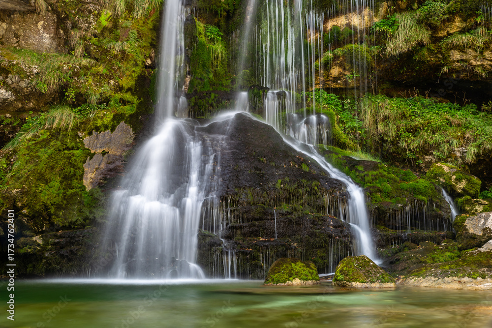Obraz premium Long exposure of beautiful cascading Virje Waterfall in green nature, Slovenia, Europe