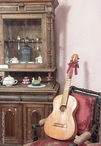 A room with an antique carved wardrobe and an antique guitar