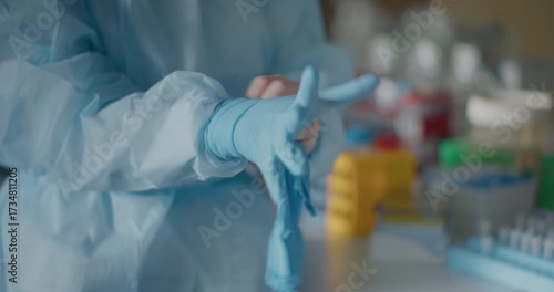 Scientist Donning Protective Gloves in Laboratory