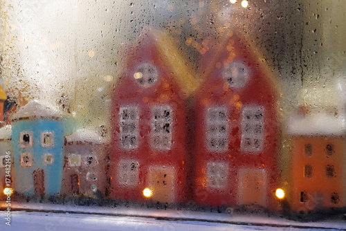 Colorful houses and garland in the window of Christmas toy store