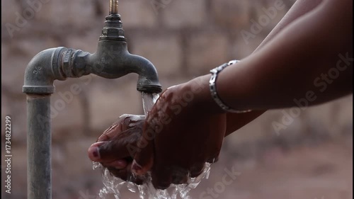Washing african hands under a running water tap