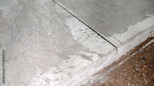 Bild auf Leinwand Concrete sidewalk showing crack and wet surface detail