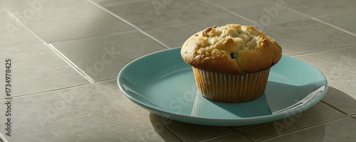 Chocolate chip muffin on mint plate close up. Freshly baked cupcake with chocolate chips. Muffin on tiled background with empty bright space. Homemade chocolate chip cupcake on mint dish.