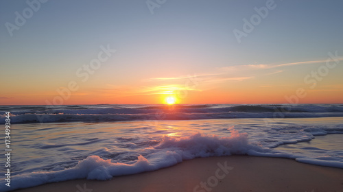 Sunset on beach, waves crashing in sand.