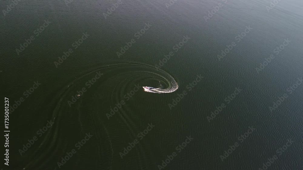 Speedboat Executes a Circular Turn and Creates Wave Patterns on a Dark ...