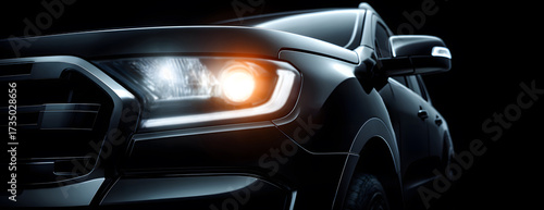 Wallpaper Mural close-up of the front headlight on a sleek black car illuminated by white light against a dark background, modern sporty design isolated and contemporary style Torontodigital.ca