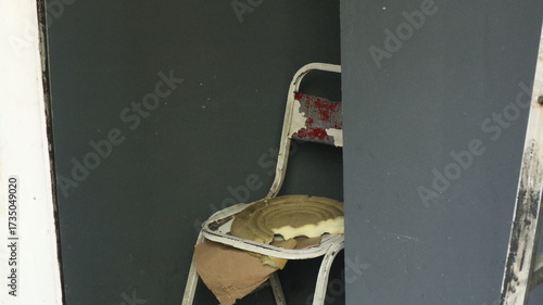 a broken chair made of iron that the owner keeps in the warehouse. Even though it is broken, sometimes people still like to sit on this chair even though it is uncomfortable.