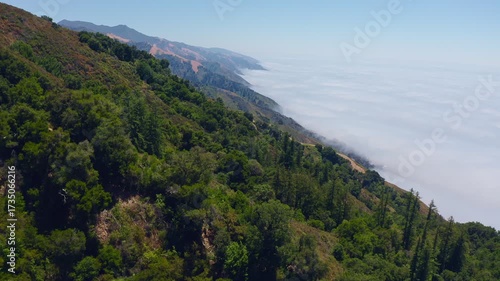 Big Sur California USA video footage of scenic mountain ridges covered with green forest and coastal fog rolling in from the Pacific Ocean along Highway 1, iconic landscape of Californias central