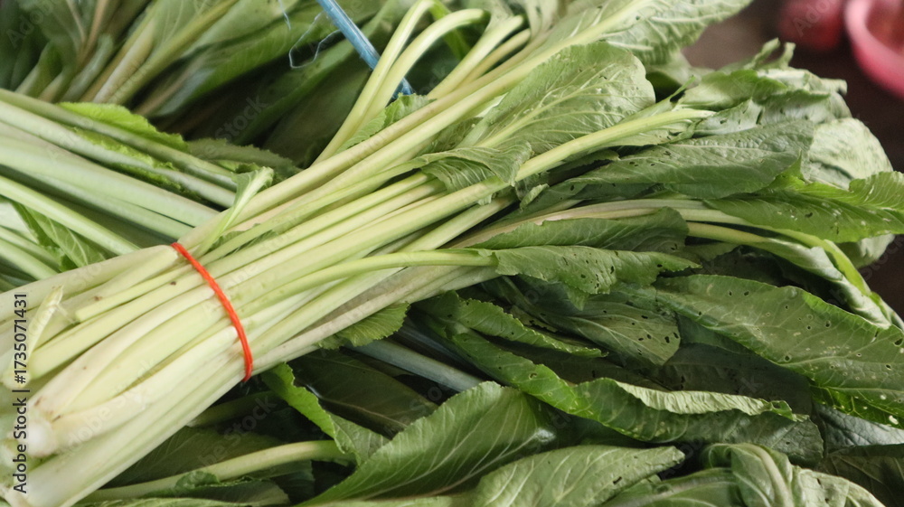 Obraz premium fresh mustard greens tied to the stalls of Indonesian traditional market sellers