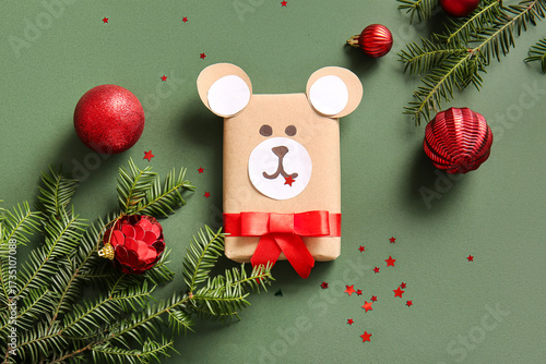 Beautiful composition with gift box, fir branches and Christmas balls on gree...